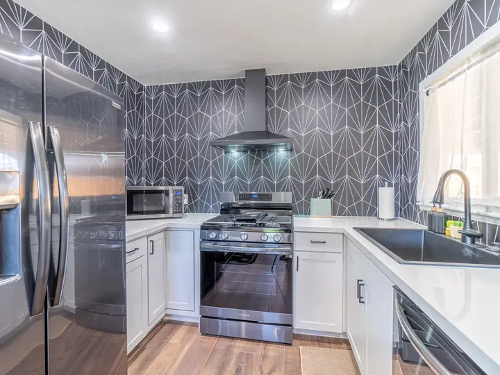 Clemson kitchen after: white shaker cabinets and geometric backsplash