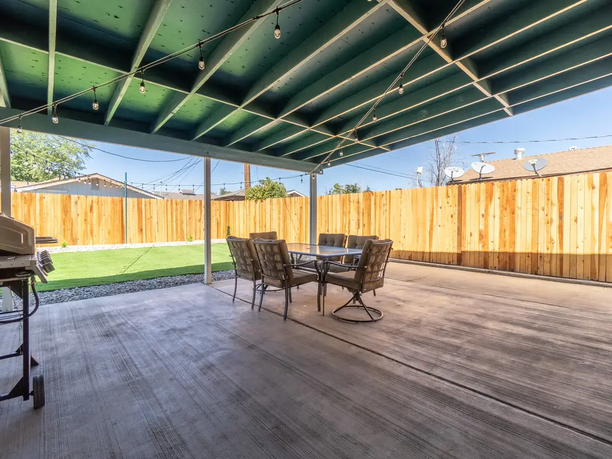 Clemson backyard after: covered patio with string lights and turf