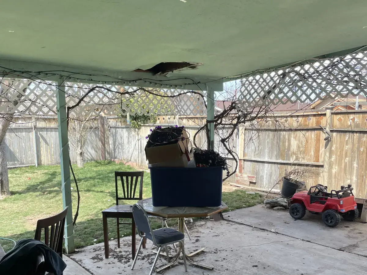 Clemson backyard before: damaged patio roof and debris