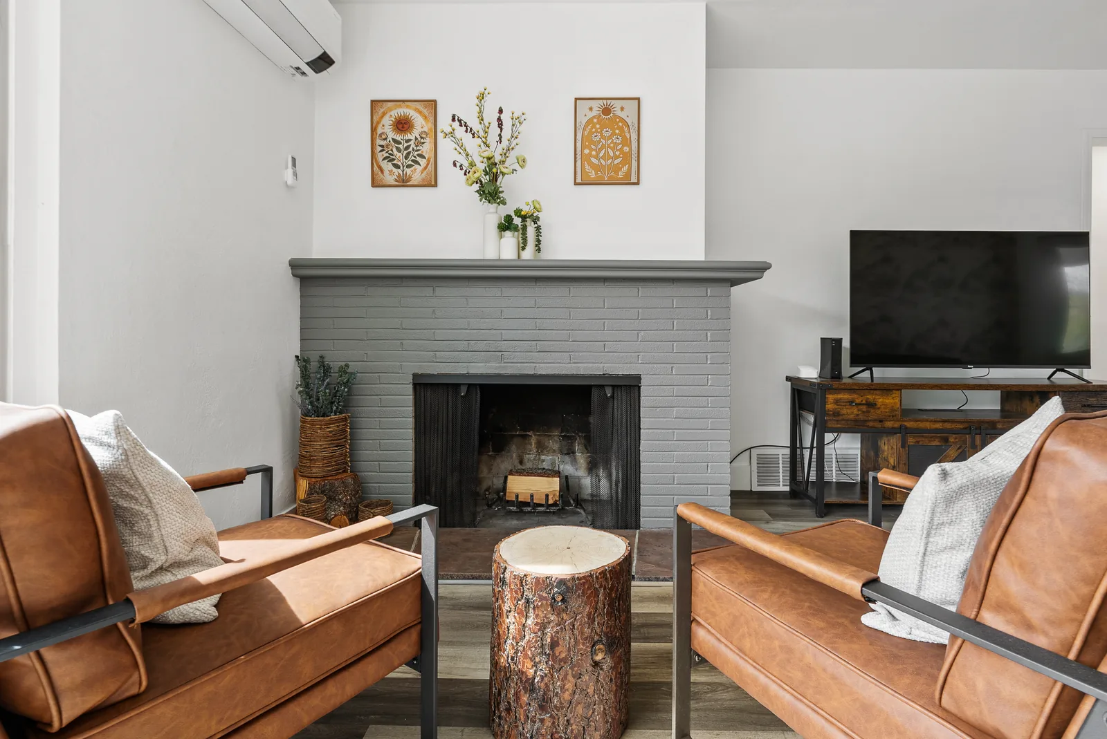 Glenmanor fireplace lounge after: leather chairs, log-round table, botanical art and styled mantel