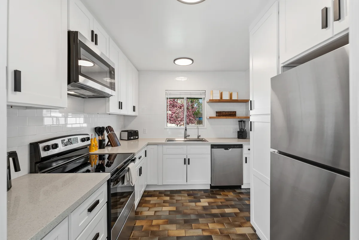Glenmanor kitchen: white shaker cabinets, stainless appliances and subway-tile backsplash