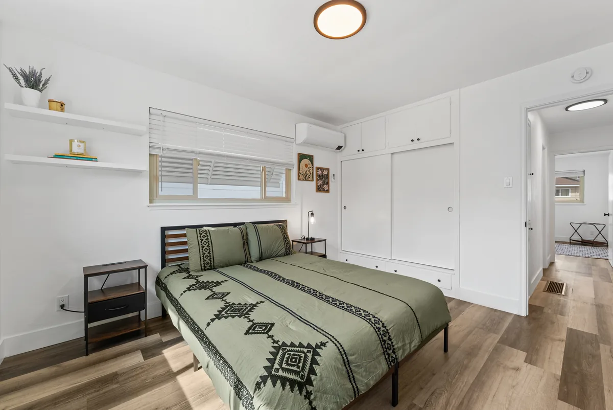Glenmanor bedroom with green-patterned bedding and floating shelves