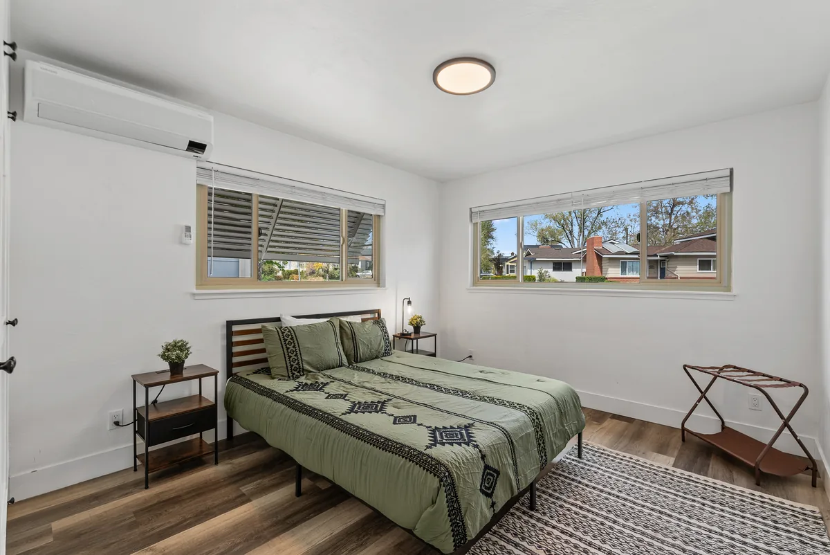 Glenmanor second bedroom with twin windows and styled bed