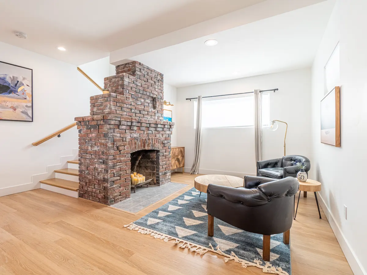 Liberty St living room after: furnished lounge with restored brick fireplace