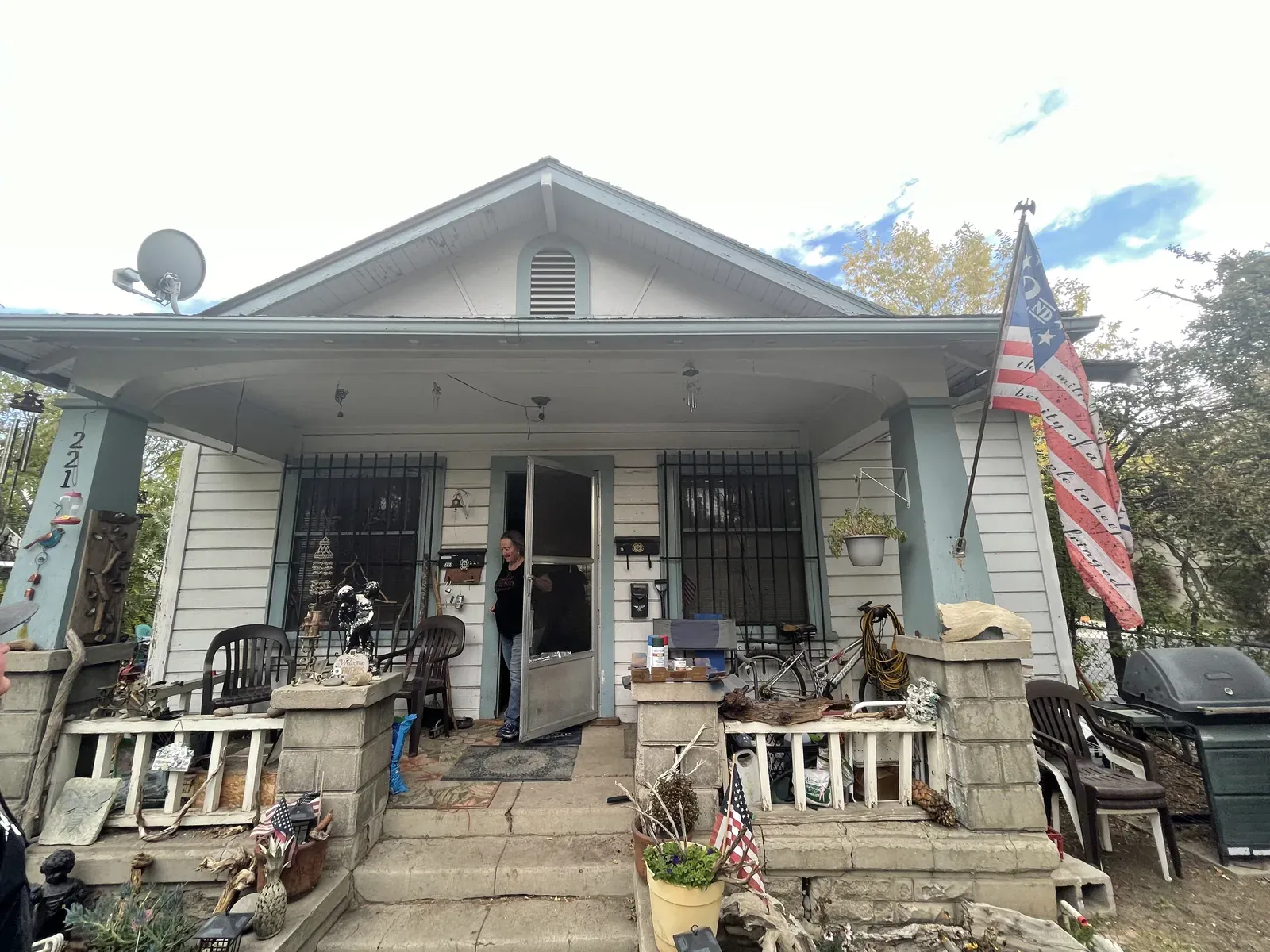 Vine St front porch before: weathered siding, cluttered porch with mismatched furniture